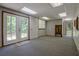 Finished basement with neutral walls and carpeting, and French doors leading out to the backyard at 4950 Creel Rd, Chattahoochee Hills, GA 30213
