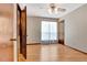 Bright bedroom featuring wood floors, ceiling fan, and large window with sheer curtains at 4950 Creel Rd, Chattahoochee Hills, GA 30213