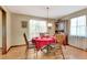 Traditional dining room with red tablecloth, wood furniture, and window with natural light at 4950 Creel Rd, Chattahoochee Hills, GA 30213
