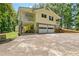 Exterior of a yellow two-story home with a covered patio and an attached garage at 4950 Creel Rd, Chattahoochee Hills, GA 30213