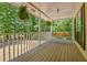 Relaxing covered front porch with hanging plants and a porch swing overlooking the wooded front yard at 4950 Creel Rd, Chattahoochee Hills, GA 30213