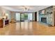 Bright and spacious living room featuring a stone fireplace, hardwood floors, and a glass door to the outside deck at 4950 Creel Rd, Chattahoochee Hills, GA 30213