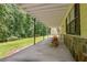Long covered patio with stone accents and metal support columns, great for entertaining at 4950 Creel Rd, Chattahoochee Hills, GA 30213