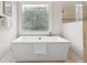 This bathroom features a soaking tub below a leaded glass window at 5105 Deerlake Dr, Alpharetta, GA 30005