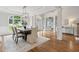 Elegant dining room with hardwood floors, wainscoting, large windows, and a modern chandelier at 5105 Deerlake Dr, Alpharetta, GA 30005
