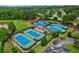 Aerial view of community tennis courts, featuring well-maintained courts, lush landscaping, and nearby parking at 5105 Deerlake Dr, Alpharetta, GA 30005