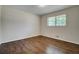 Cozy bedroom features hardwood floors, a window, and neutral wall paint at 606 Evergreen Dr, Woodstock, GA 30188