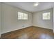 Bedroom featuring hardwood floors, two windows, and neutral wall paint at 606 Evergreen Dr, Woodstock, GA 30188