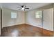 Bedroom with hardwood floors, ceiling fan, and natural light from two windows at 606 Evergreen Dr, Woodstock, GA 30188