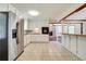 Well-lit kitchen features white cabinets, stainless steel appliances, and tile flooring at 606 Evergreen Dr, Woodstock, GA 30188