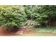 Lush backyard featuring a serene water feature, a wooden bridge, and mature trees, creating a private oasis at 161 Highgrove Dr, Suwanee, GA 30024