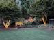 Beautiful backyard landscape with illuminated stone steps, lush plants, and a charming gazebo, perfect for evening relaxation at 161 Highgrove Dr, Suwanee, GA 30024