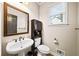 Powder room features a pedestal sink, a decorative mirror, and wood-look flooring at 161 Highgrove Dr, Suwanee, GA 30024