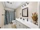 Well-lit bathroom with a vanity, decorative mirror, and shower at 161 Highgrove Dr, Suwanee, GA 30024