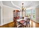 Formal dining room featuring hardwood floors, classic chandelier, and wainscoting for an elegant touch at 161 Highgrove Dr, Suwanee, GA 30024