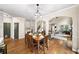 Open-concept dining area with hardwood floors, modern lighting, and easy access to the kitchen and living spaces at 161 Highgrove Dr, Suwanee, GA 30024