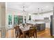 Spacious dining area with hardwood floors flowing into a modern kitchen with stainless steel appliances and island seating at 161 Highgrove Dr, Suwanee, GA 30024