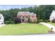 Beautiful two-story brick home with a spacious lawn and mature trees at 161 Highgrove Dr, Suwanee, GA 30024