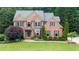 Charming two-story brick home with a well-manicured lawn and lush landscaping at 161 Highgrove Dr, Suwanee, GA 30024