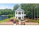 Scenic gazebo near tennis court with stone base, white railings and stairs to wooded area at 161 Highgrove Dr, Suwanee, GA 30024