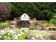 A beautiful Grand Cascades waterfall pond with stone details and vibrant flowers at 161 Highgrove Dr, Suwanee, GA 30024
