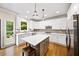 Eat-in kitchen boasts white cabinetry, stainless appliances, center island, and a view from over the kitchen sink at 161 Highgrove Dr, Suwanee, GA 30024