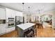Bright kitchen with white cabinets, stainless steel appliances and center island that has seating for three at 161 Highgrove Dr, Suwanee, GA 30024