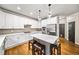 Modern kitchen with white cabinets, stainless steel appliances, white countertops, island with stools and hardwood floors at 161 Highgrove Dr, Suwanee, GA 30024