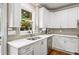 Clean kitchen featuring white cabinets, stainless steel appliances and a stainless steel sink looking out on nature at 161 Highgrove Dr, Suwanee, GA 30024