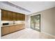 Bright kitchenette with granite countertops, wood cabinets, and patio access at 161 Highgrove Dr, Suwanee, GA 30024