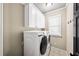 Functional laundry room equipped with modern washer/dryer, overhead cabinets, and tiled flooring at 161 Highgrove Dr, Suwanee, GA 30024