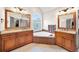 Elegant bathroom featuring dual vanities, soaking tub, and arched window at 161 Highgrove Dr, Suwanee, GA 30024