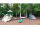 Community playground featuring a slide, climbing wall, and spring rider, surrounded by trees at 161 Highgrove Dr, Suwanee, GA 30024