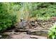 Charming rock garden with a frog fountain feature, bringing character and tranquility to the backyard at 161 Highgrove Dr, Suwanee, GA 30024
