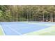 Well-maintained tennis court featuring benches and lighting at 161 Highgrove Dr, Suwanee, GA 30024
