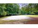 Outdoor sand volleyball court surrounded by lush greenery and basketball courts in a well-maintained community space at 161 Highgrove Dr, Suwanee, GA 30024
