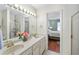 A well-lit bathroom features a double vanity, shower with sliding doors, and a view to the main bedroom at 2565 Holcomb Springs Dr, Alpharetta, GA 30022