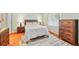 Comfortable bedroom with neutral walls, wood furniture, and a patterned rug at 2565 Holcomb Springs Dr, Alpharetta, GA 30022