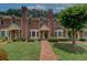 Lovely brick townhome with manicured lawn and inviting walkway to the front door at 2565 Holcomb Springs Dr, Alpharetta, GA 30022