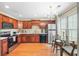 Bright kitchen with wood cabinetry, stainless steel appliances, and a dining table by the window at 2565 Holcomb Springs Dr, Alpharetta, GA 30022