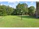 Expansive lawn and landscape in backyard featuring a dark wooden deck, brick home, and a vintage street lamp at 327 Awendaw Cir, Ellenwood, GA 30294