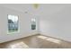 Bedroom with wood floors and a double window view of a lush green lawn and trees, plus neutral paint at 327 Awendaw Cir, Ellenwood, GA 30294