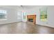 Cozy living room featuring a brick fireplace, wood-look flooring, and natural light from multiple windows at 327 Awendaw Cir, Ellenwood, GA 30294