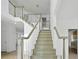 Bright foyer with a staircase featuring painted wood treads and white risers and railings, with hardwood floors, leads to the upper level at 327 Awendaw Cir, Ellenwood, GA 30294