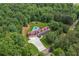 Stunning aerial view of estate featuring a red roof, inground pool, and mature trees at 425 Chadwick Pl, Canton, GA 30114