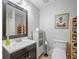 Well-lit bathroom featuring a vanity, toilet, wine racks and framed decorative art at 425 Chadwick Pl, Canton, GA 30114