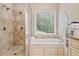 Bright bathroom featuring a tub, shower, window, and tile flooring at 425 Chadwick Pl, Canton, GA 30114