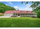 Stunning home with a red roof, wraparound porch, and well-manicured lawn at 425 Chadwick Pl, Canton, GA 30114