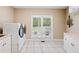 Bright laundry room features a washer, dryer, sink, and window to backyard at 425 Chadwick Pl, Canton, GA 30114