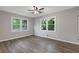 Bedroom featuring hardwood floors, ceiling fan, and two double hung windows at 679 Creek View Dr, Lawrenceville, GA 30044